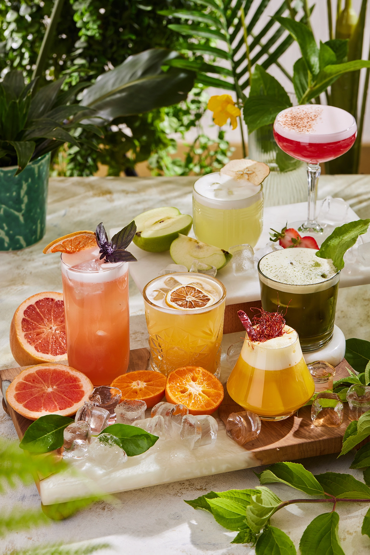 Assorted fresh fruit beverages and smoothies presented in a vibrant tropical setting with citrus fruits and natural ingredients.