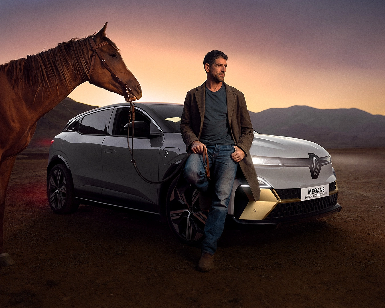 Renault Megane E-Tech electric vehicle with rider and horse at sunset in mountain landscape