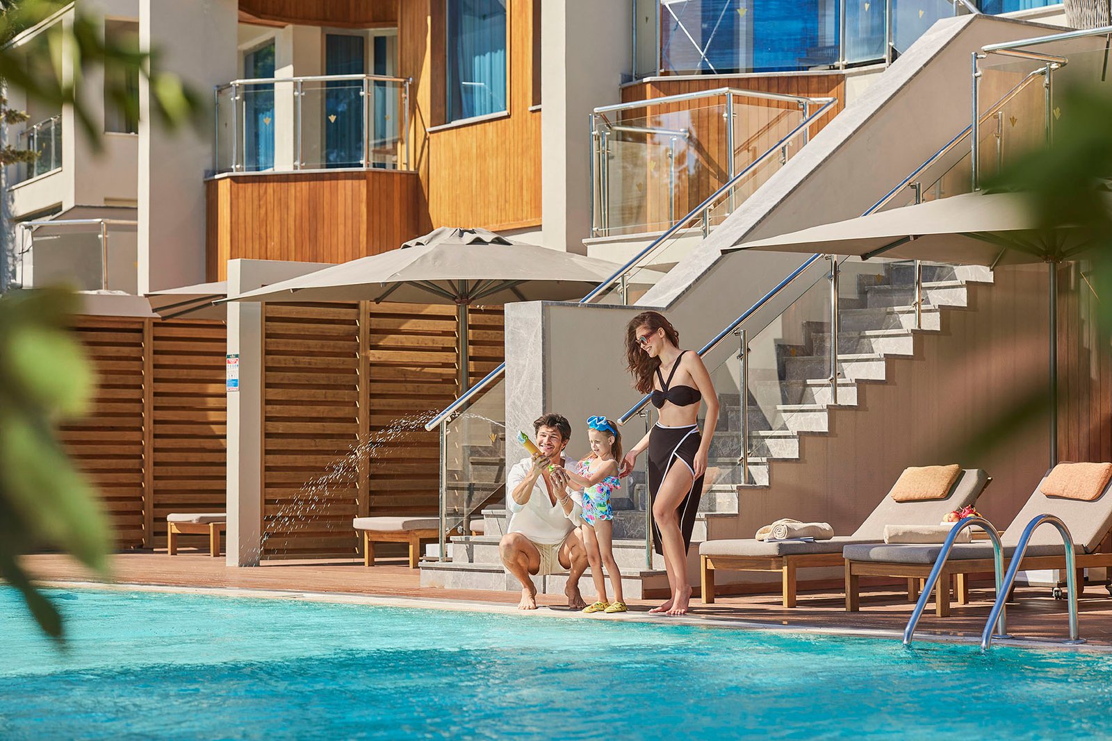 Family enjoying quality time by the pool at Rixos Sungate Hotel in Antalya, highlighting luxury family resort experiences and Mediterranean hospitality.