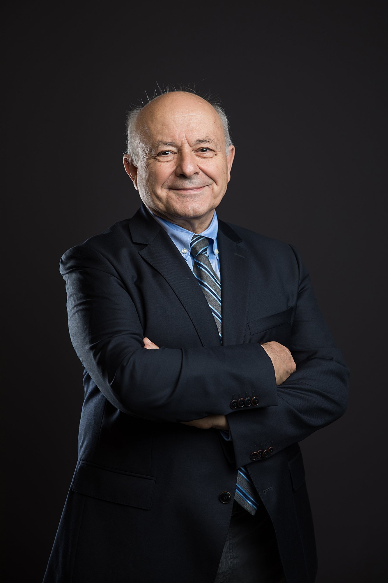 Professional studio portrait of a company team member photographed against a dark background with controlled lighting.