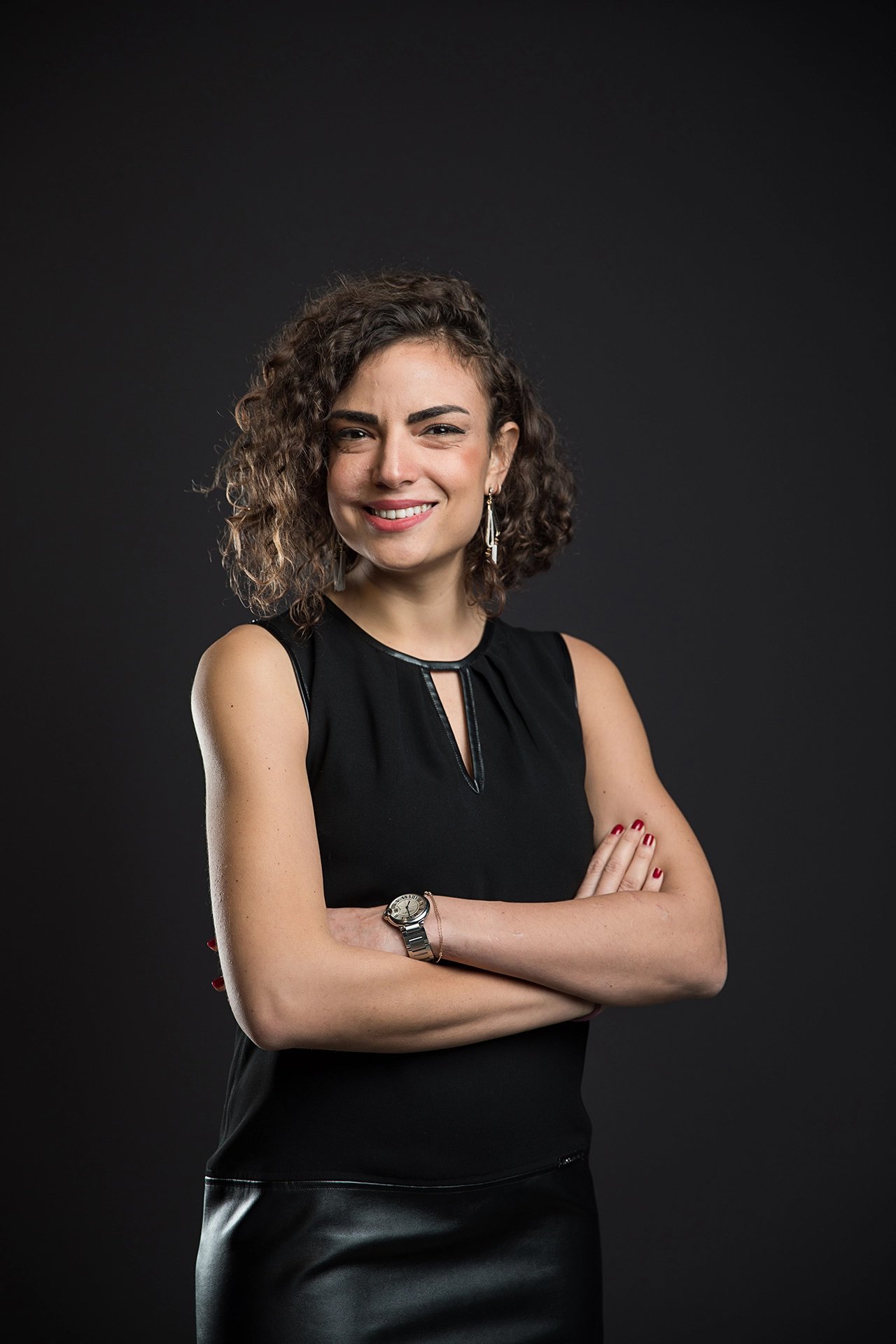 Professional studio portrait of a company team member photographed against a dark background with controlled lighting.