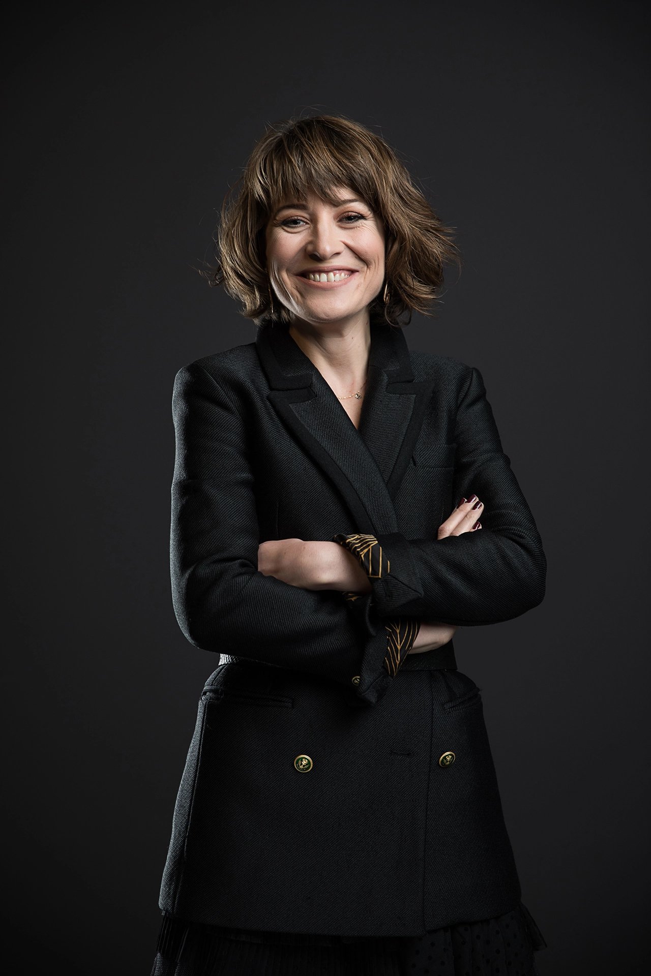 Professional studio portrait of a company team member photographed against a dark background with controlled lighting.