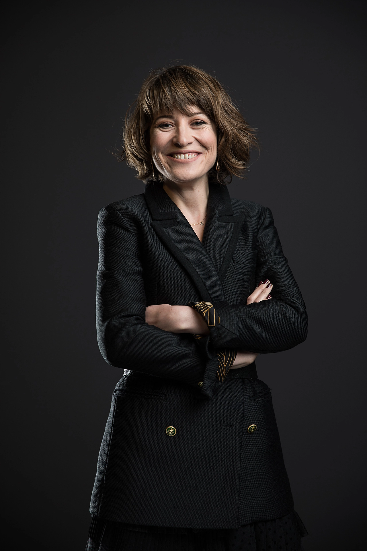 Professional portrait of a female executive with crossed arms, photographed for LinkedIn profile, leadership branding and corporate communications.