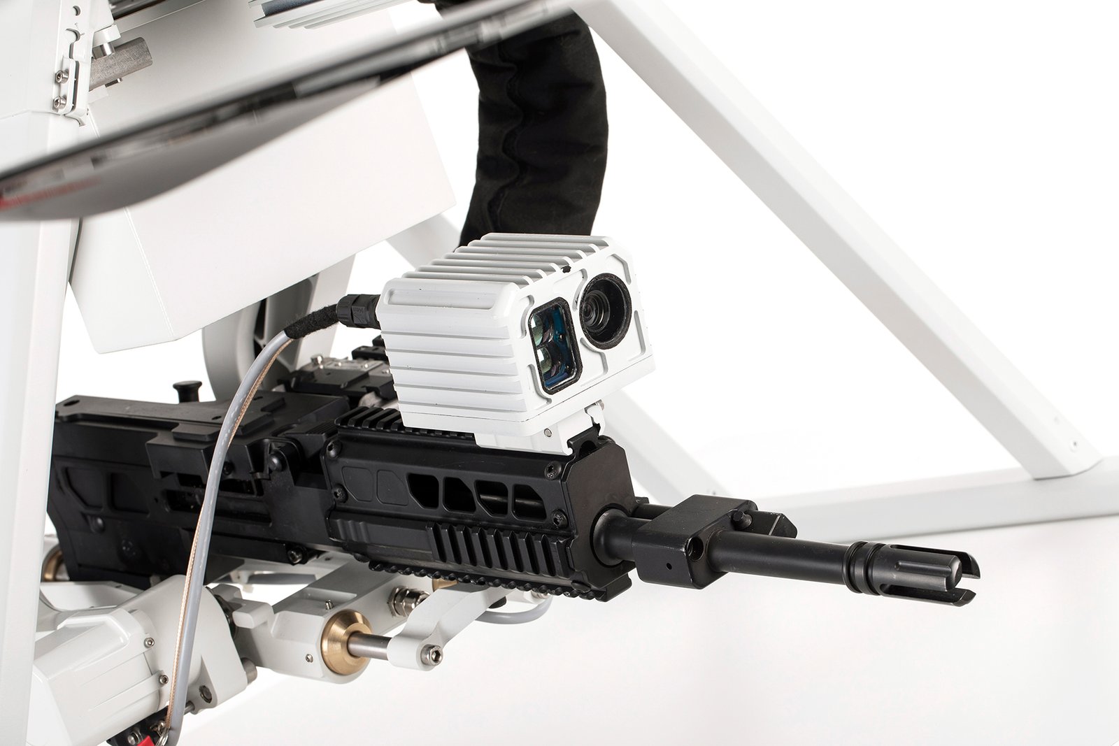 Professional commercial defense product photographs by Sinan Niyazi Kutsal for ASISGUARD, showcasing the SONGAR armed military drone hexacopter equipped with an automatic gun payload alongside its digital ground control station monitor on a studio background.