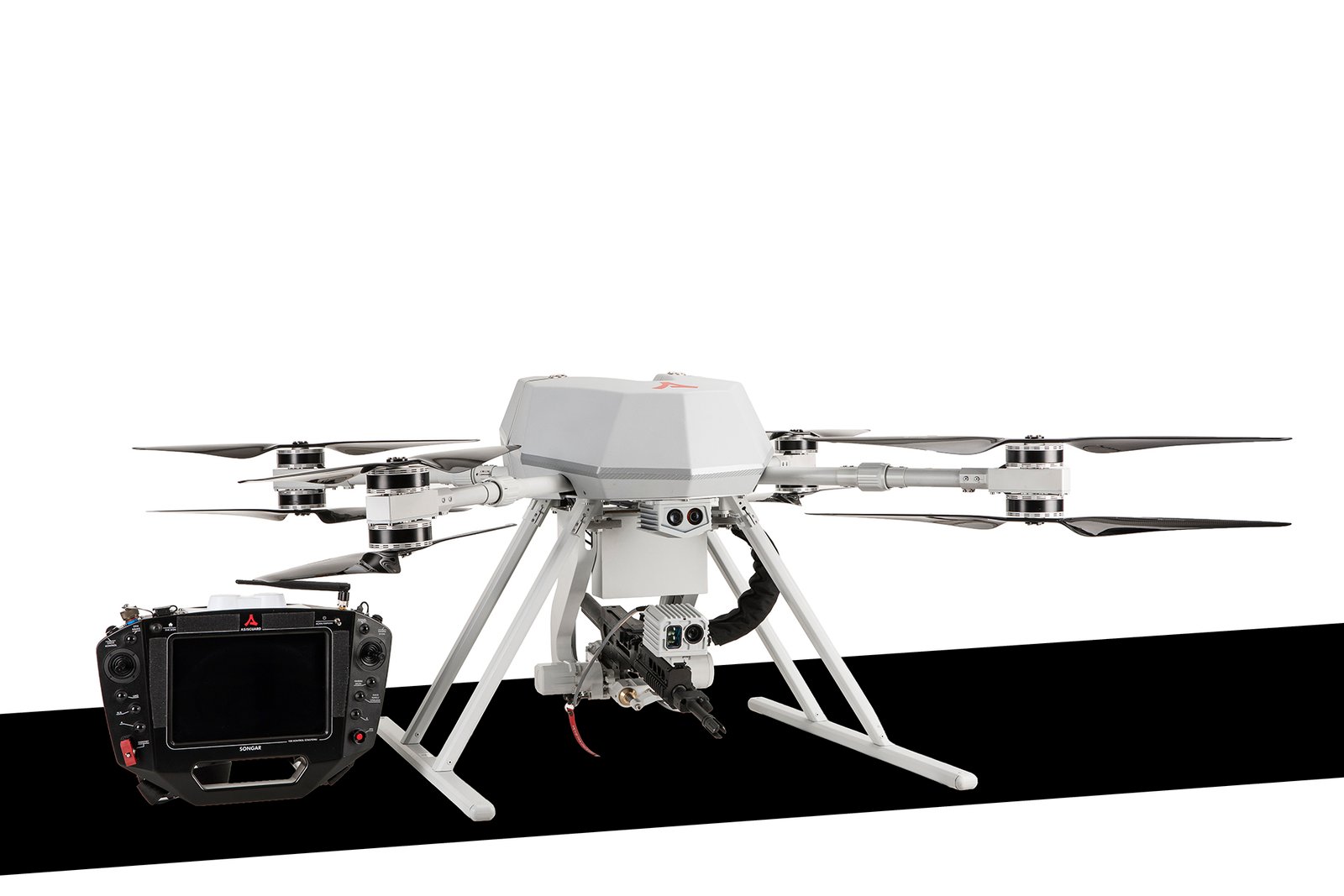 Professional commercial defense product photographs by Sinan Niyazi Kutsal for ASISGUARD, showcasing the SONGAR armed military drone hexacopter equipped with an automatic gun payload alongside its digital ground control station monitor on a studio background.