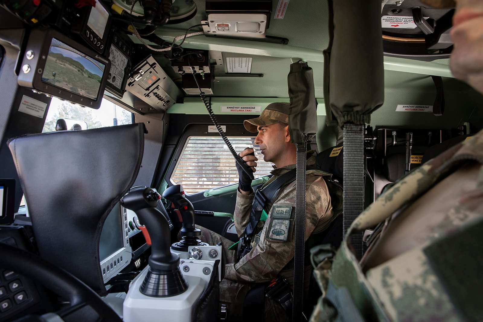 Professional commercial defense product photographs by Sinan Niyazi Kutsal for ASISGUARD, showcasing rugged military vehicle display monitors, armored vehicle intercommunication boxes, and multi-channel tactical screens over a clean studio setup.