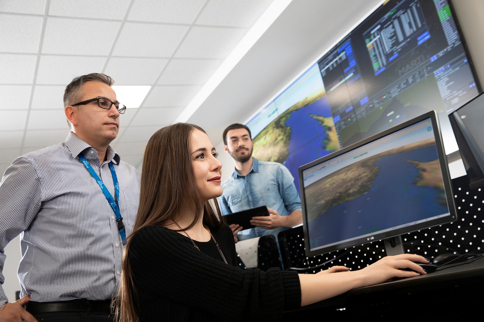 Professional commercial corporate photographs by Sinan Niyazi Kutsal for Havelsan, capturing tech engineers and corporate professionals monitoring advanced digital screens, coding, and testing simulation units inside modern software development laboratories.