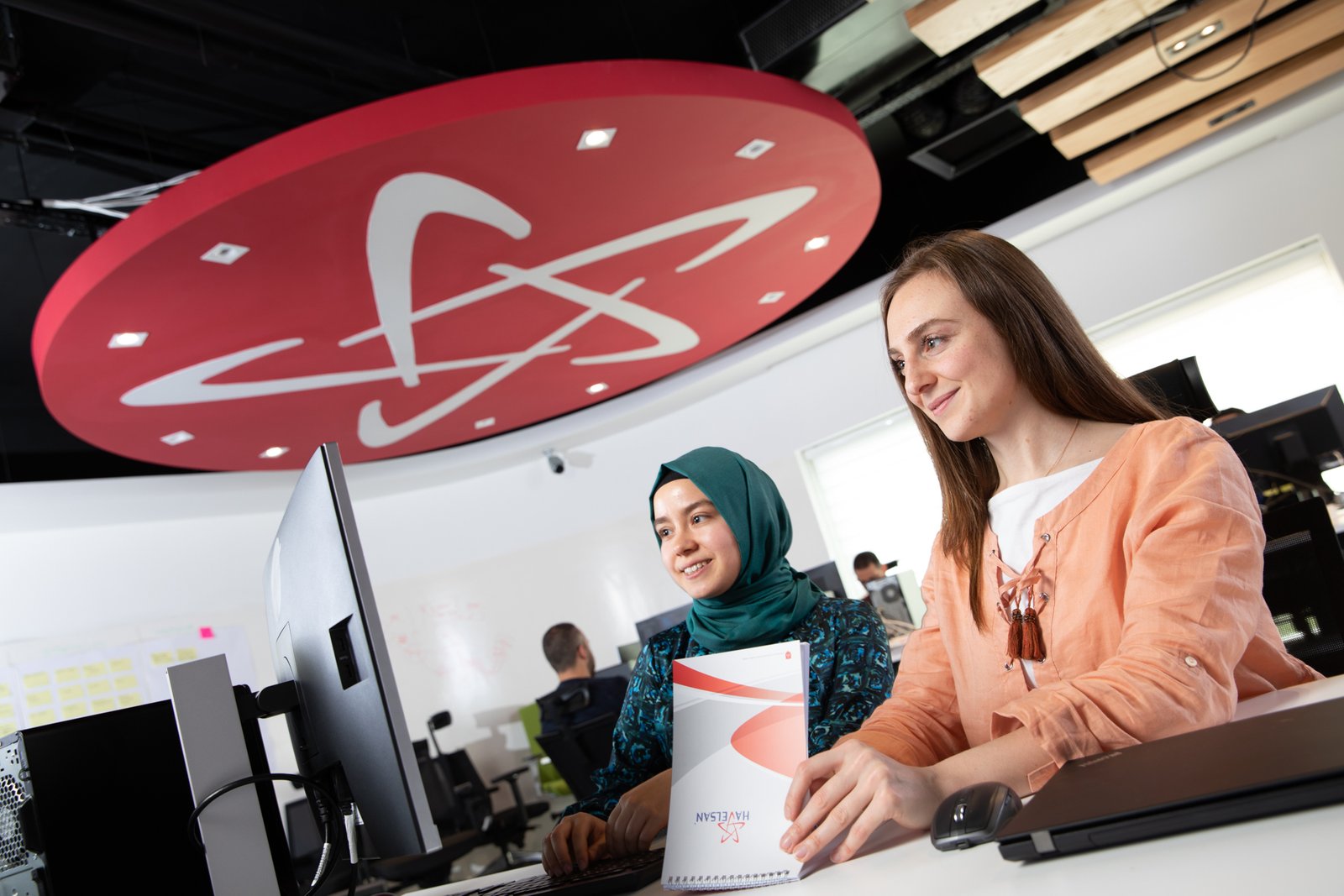 Professional commercial corporate photographs by Sinan Niyazi Kutsal for Havelsan, capturing tech engineers and corporate professionals monitoring advanced digital screens, coding, and testing simulation units inside modern software development laboratories.