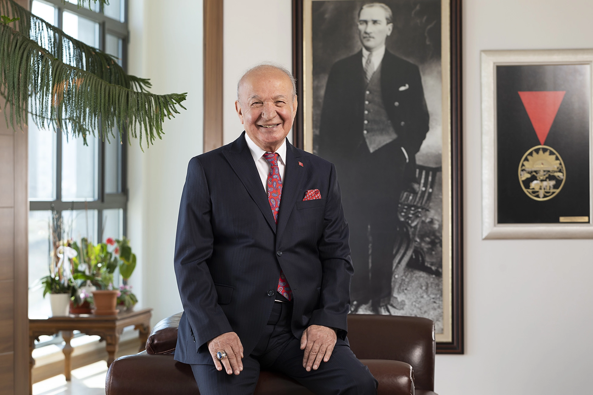 Professional portrait of a company founder and business leader photographed in a corporate office environment.