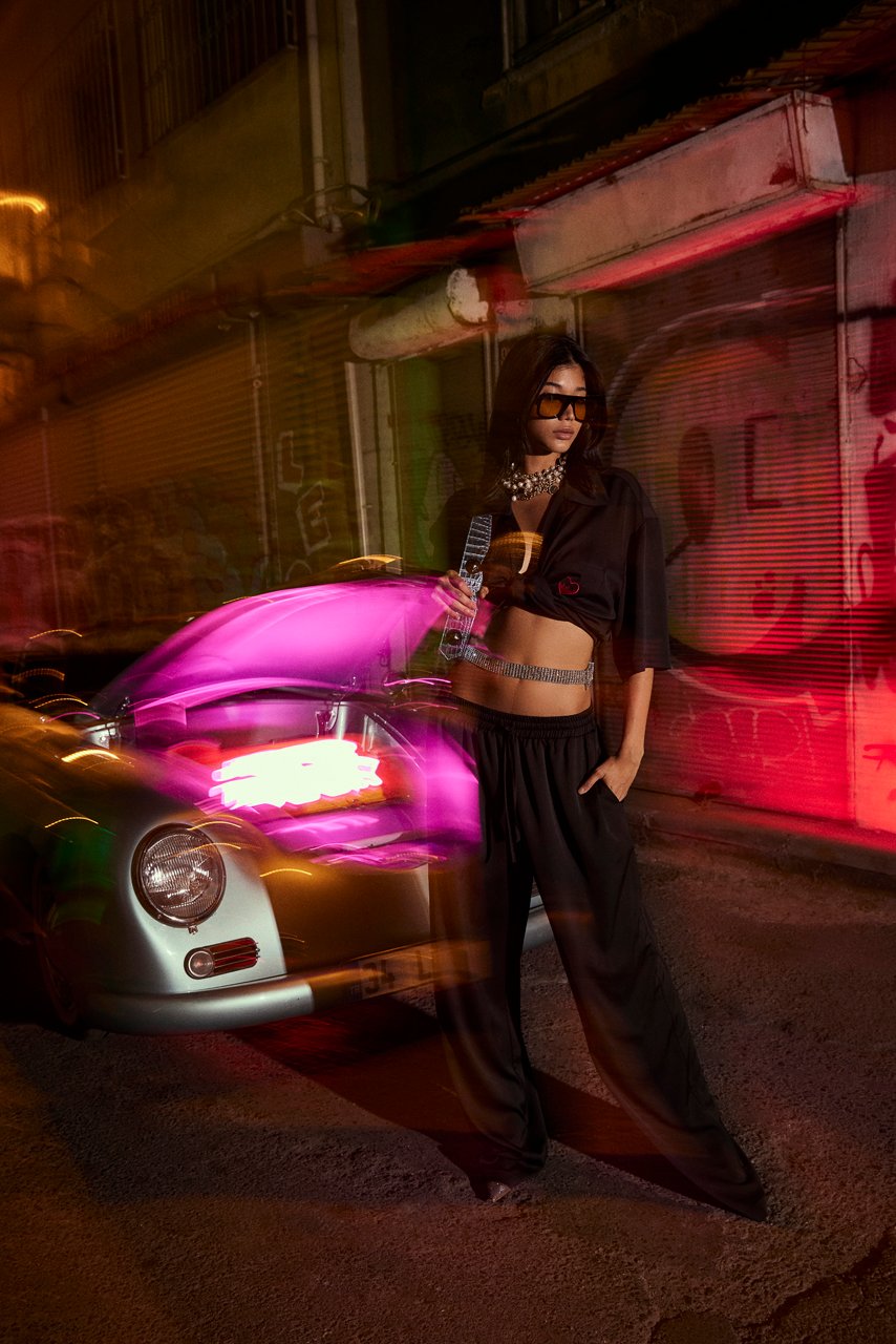 Professional commercial night fashion photographs by Sinan Niyazi Kutsal for Je te veux, capturing models posing in stylish streetwear on the gritty, neon-lit streets of Karakoy, Istanbul, alongside a vintage sports car with glowing pink light leaks.