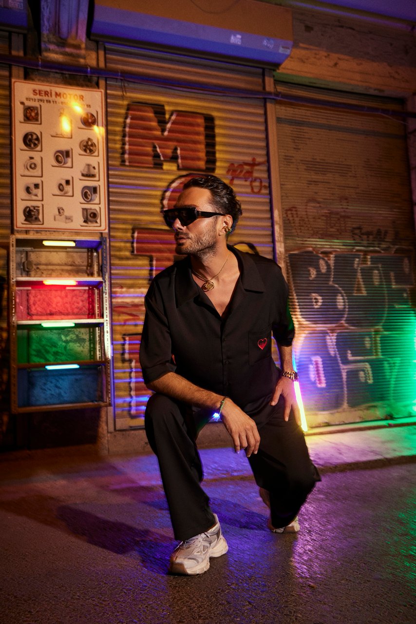 Professional commercial night fashion photographs by Sinan Niyazi Kutsal for Je te veux, capturing models posing in stylish streetwear on the gritty, neon-lit streets of Karakoy, Istanbul, alongside a vintage sports car with glowing pink light leaks.