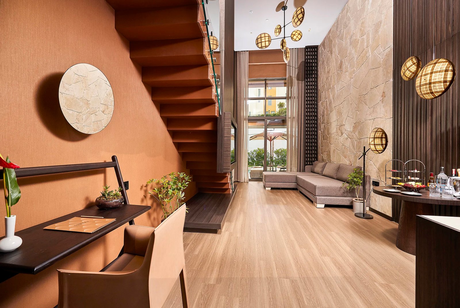 A sophisticated commercial interior photograph by Sinan Niyazi Kutsal for Lusso Sorgun, showcasing a luxury hotel bedroom with floor-to-ceiling geometric wooden dividers, a crisp white bed, and warm terracotta accent walls.