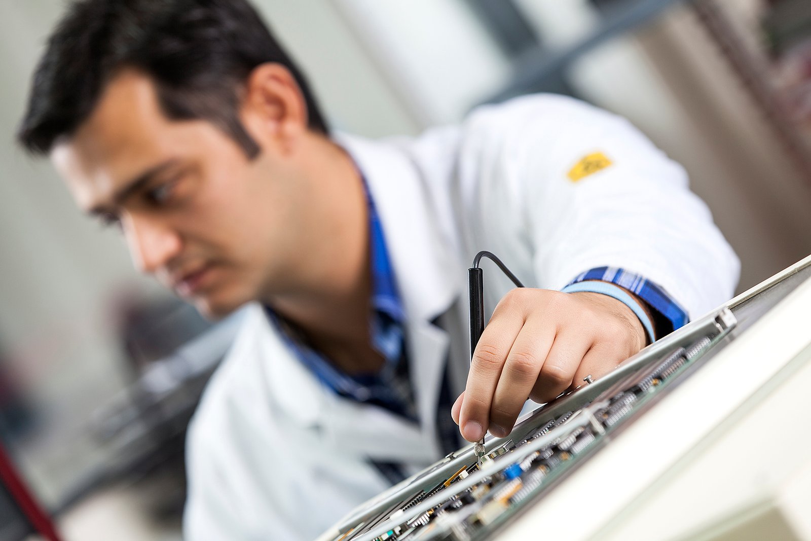 Professional commercial corporate photographs by Sinan Niyazi Kutsal for Havelsan, capturing tech engineers and corporate professionals monitoring advanced digital screens, coding, and testing simulation units inside modern software development laboratories.