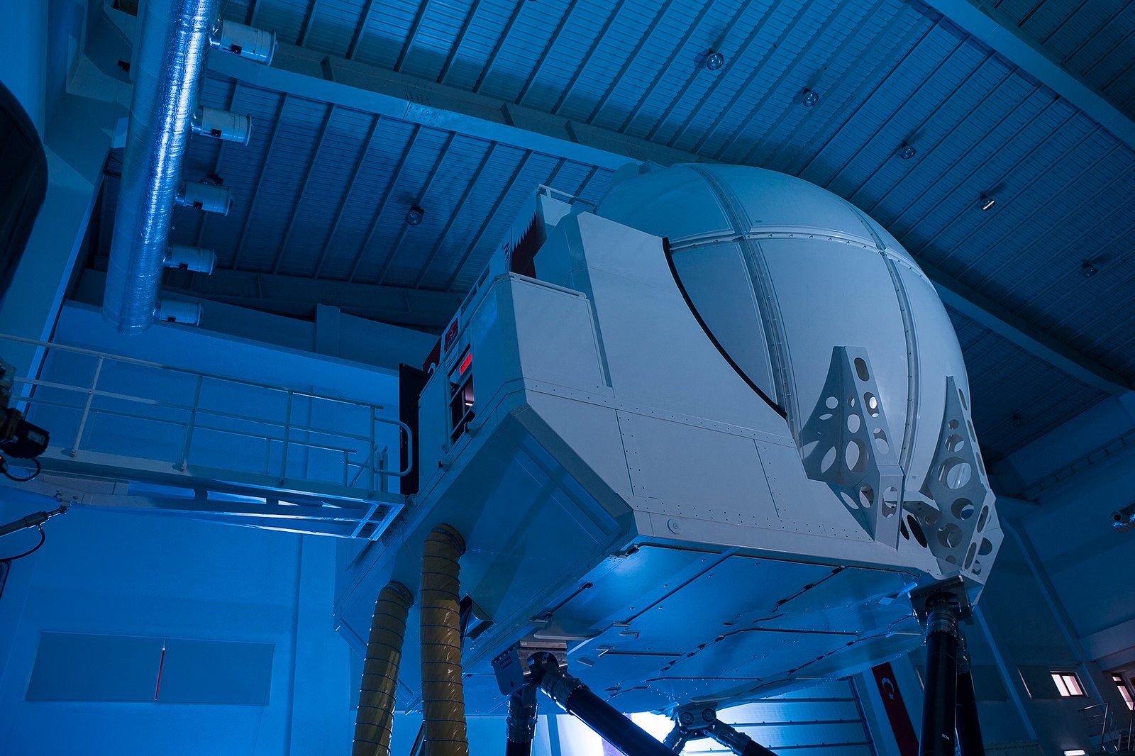 Professional commercial technology photographs by Sinan Niyazi Kutsal showcasing HAVELSAN advanced full flight simulator domes and training facilities under ambient blue lighting.