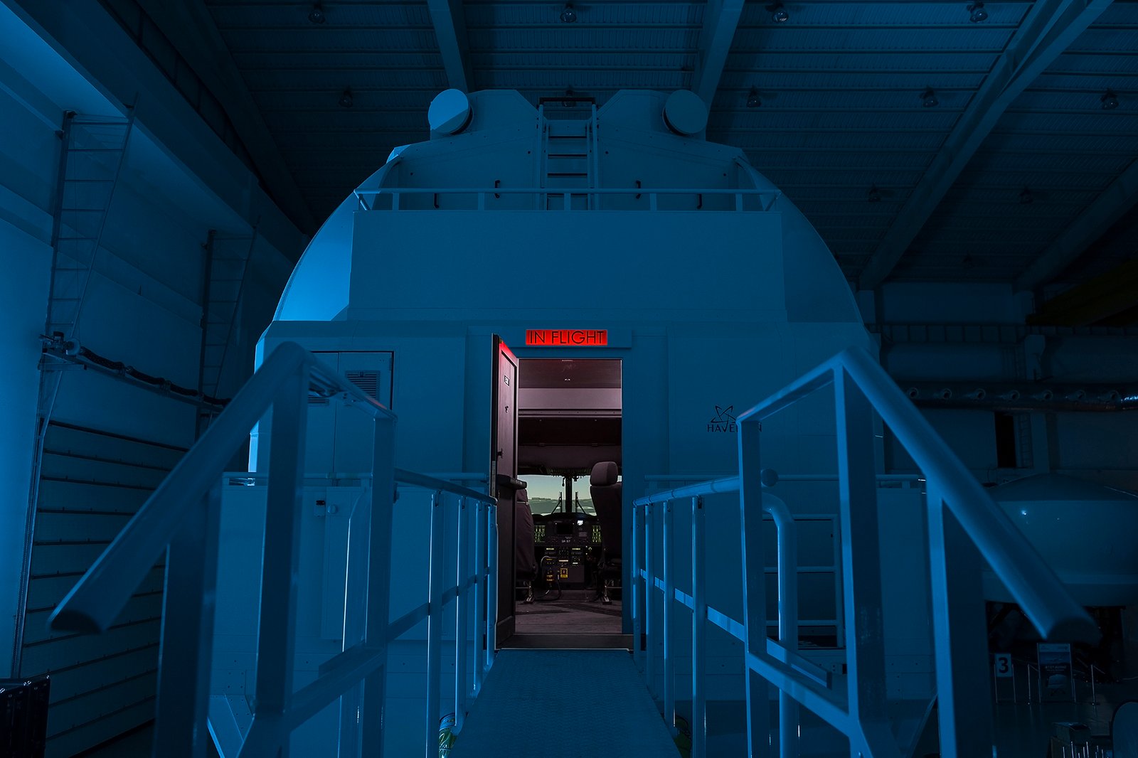 Professional commercial technology photographs by Sinan Niyazi Kutsal showcasing HAVELSAN advanced full flight simulator domes and training facilities under ambient blue lighting.