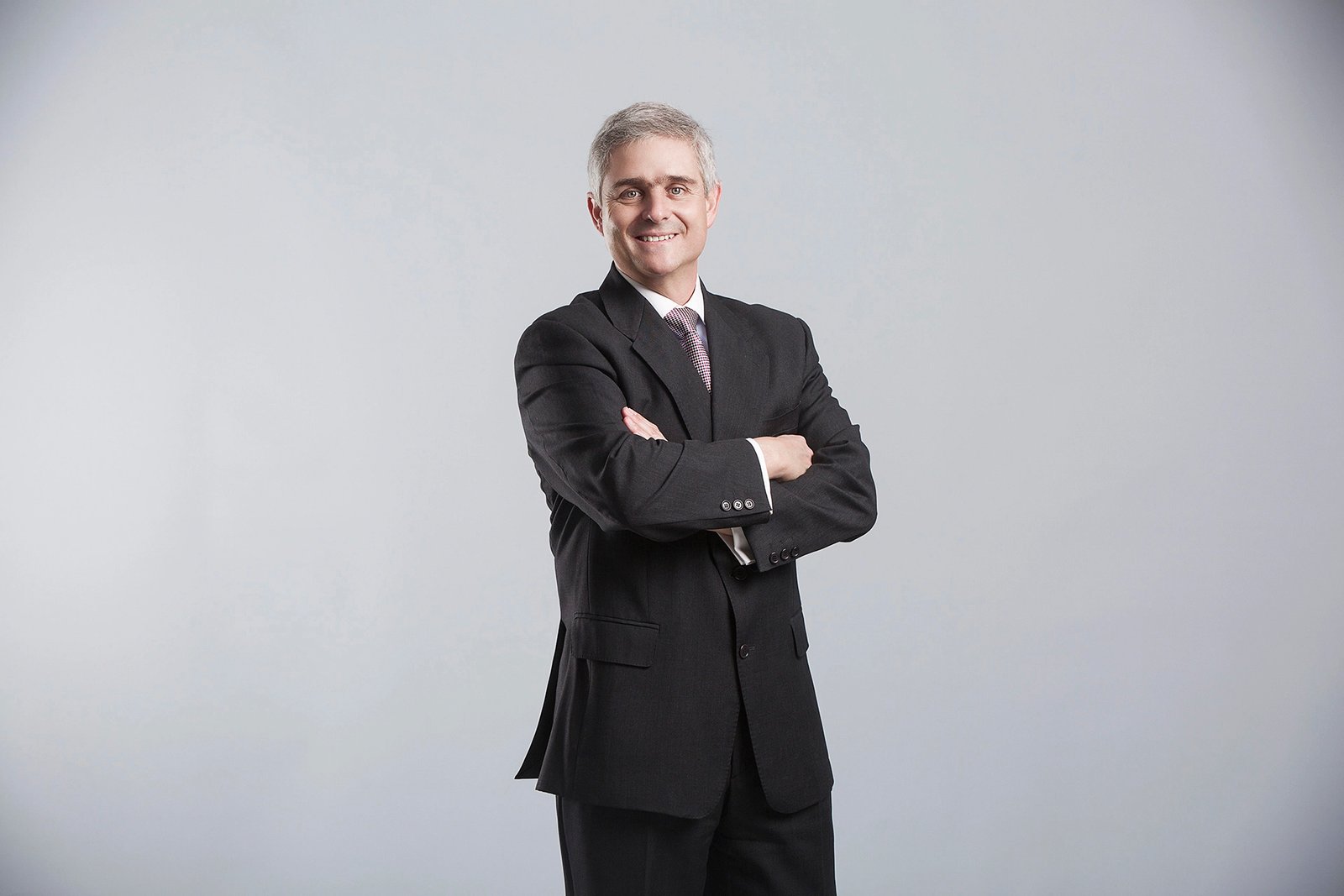 Professional executive portrait photographed in a corporate office environment.