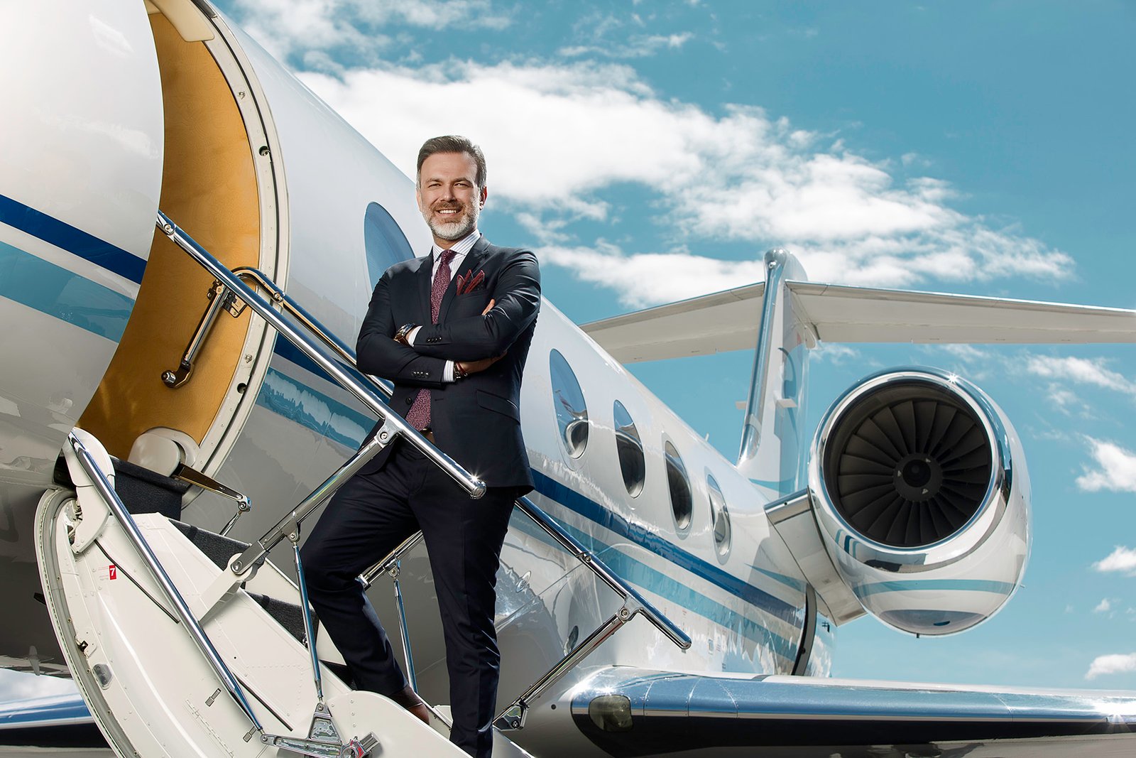 Ferhat Yenibertiz standing beside business aircraft and helicopter during an executive aviation portrait session photographed for Aviation Turkey Magazine.