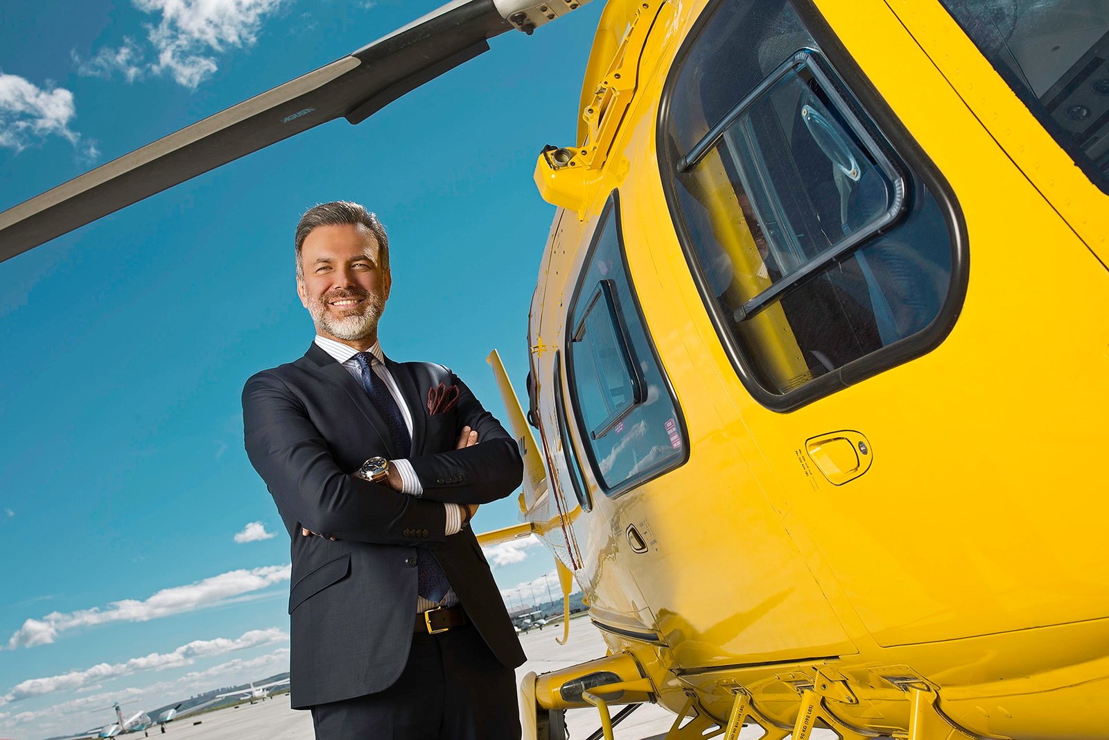 Ferhat Yenibertiz standing beside business aircraft and helicopter during an executive aviation portrait session photographed for Aviation Turkey Magazine.