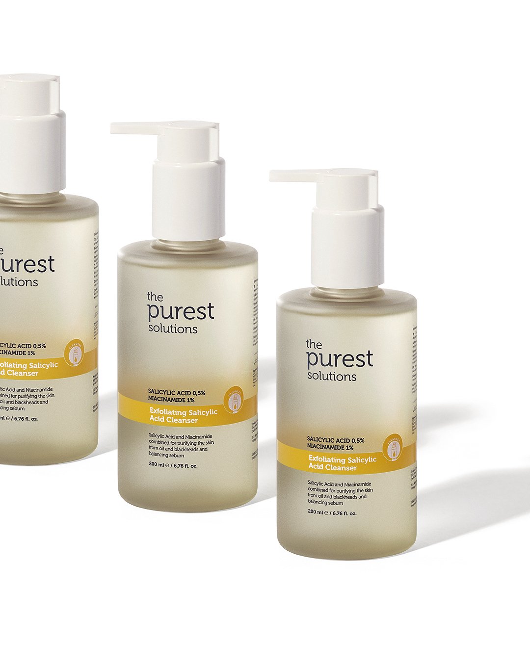 Professional commercial product advertising photographs by Sinan Niyazi Kutsal for The Purest Solutions, showcasing premium skincare serums, toners, and sunscreen tubes arranged elegantly on white geometric props with water drops.
