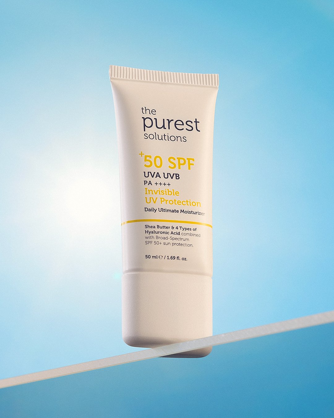 Professional commercial product advertising photographs by Sinan Niyazi Kutsal for The Purest Solutions, showcasing premium skincare serums, toners, and sunscreen tubes arranged elegantly on white geometric props with water drops.
