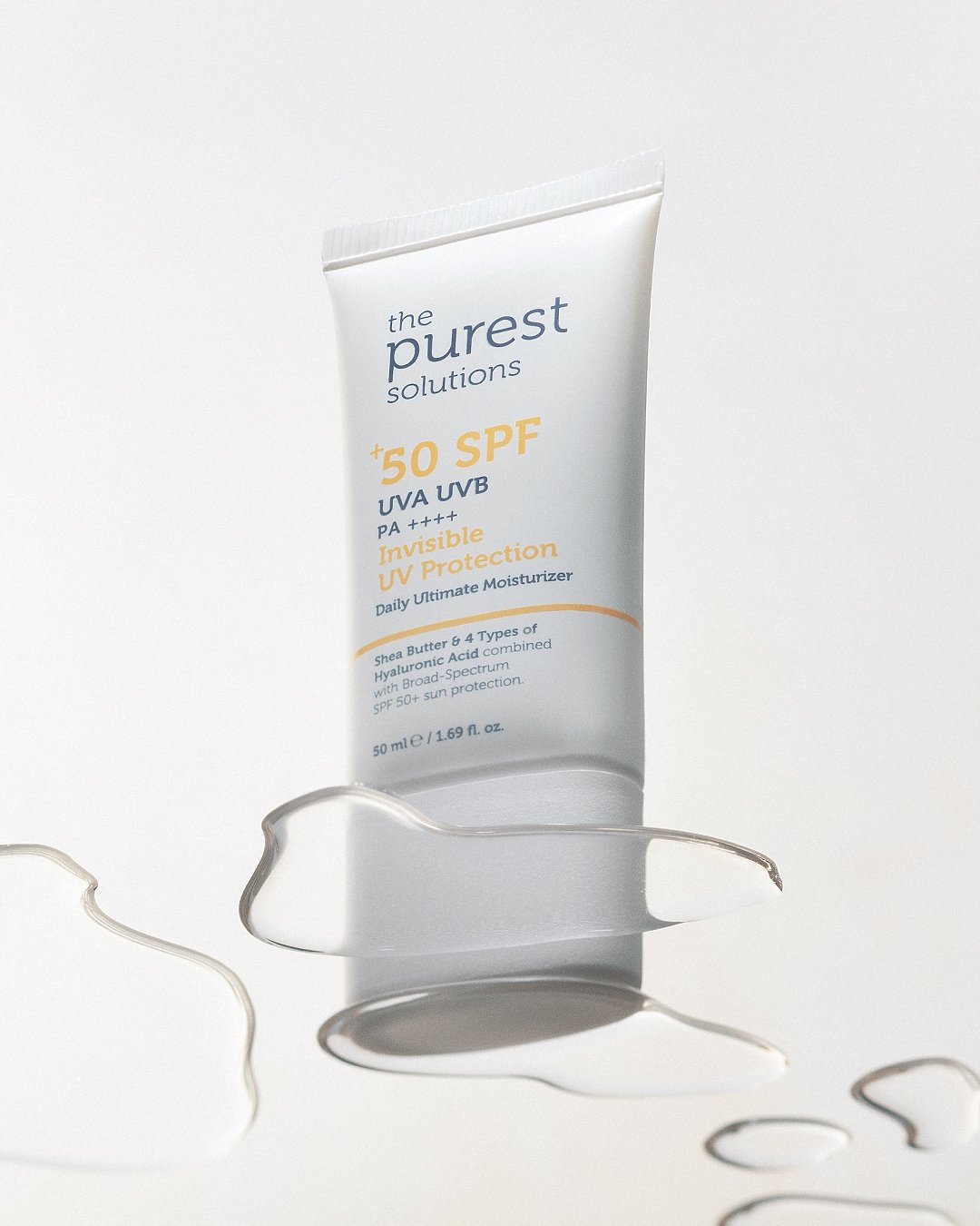 Professional commercial product advertising photographs by Sinan Niyazi Kutsal for The Purest Solutions, showcasing premium skincare serums, toners, and sunscreen tubes arranged elegantly on white geometric props with water drops.