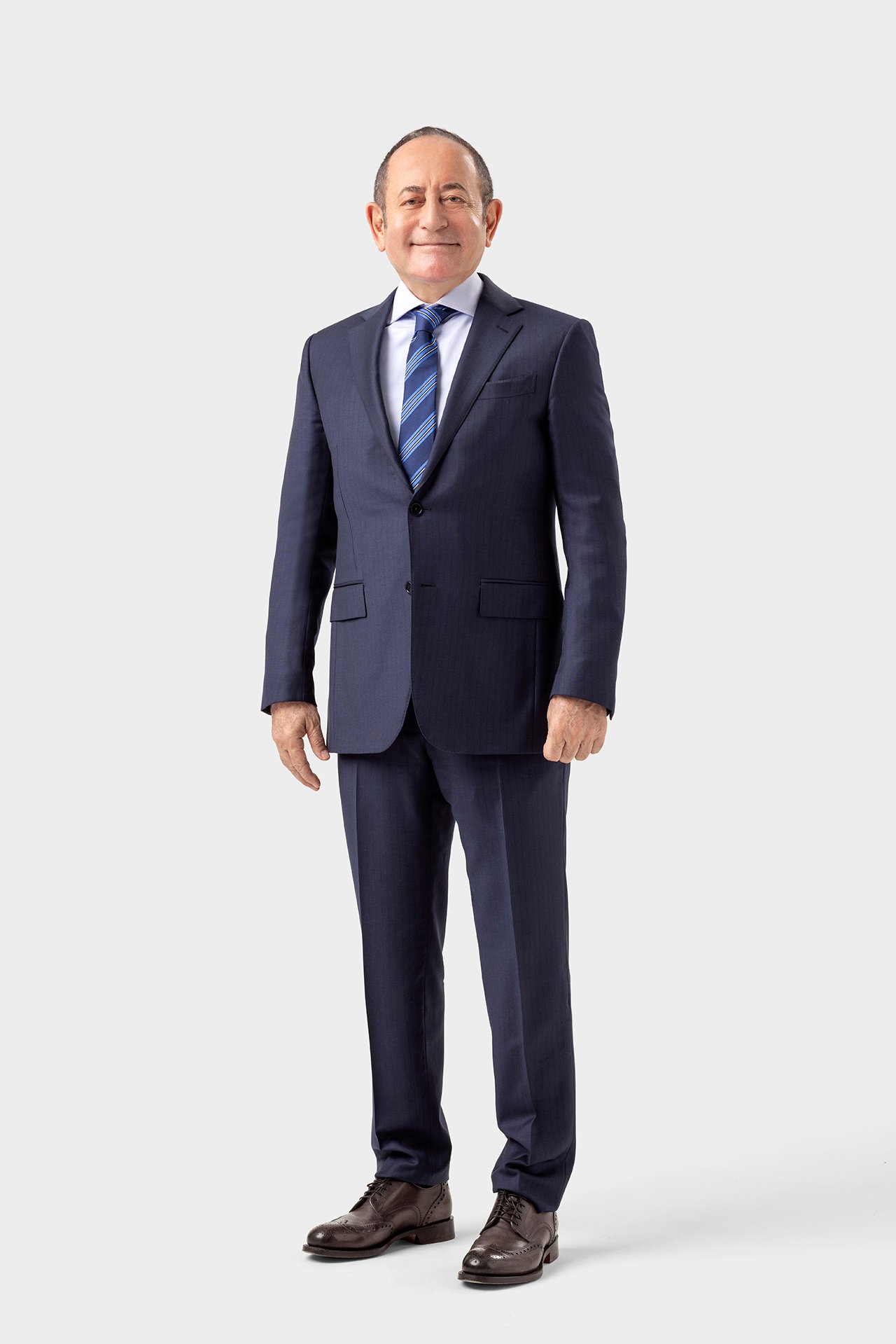 Akif Hamzaçebi standing in a formal suit for a studio political portrait against a light background.
