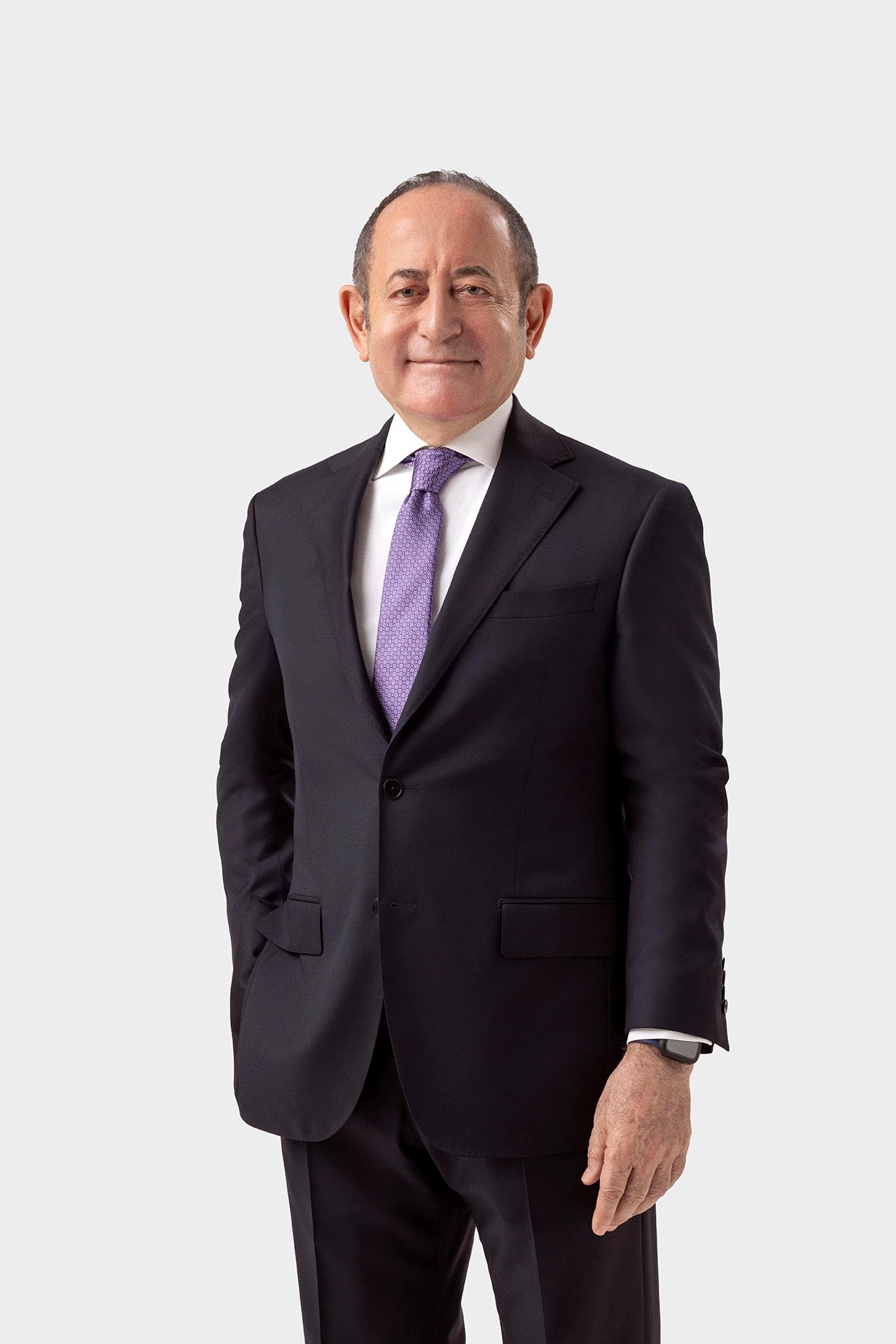 Akif Hamzaçebi standing in a formal suit for a studio political portrait against a light background.