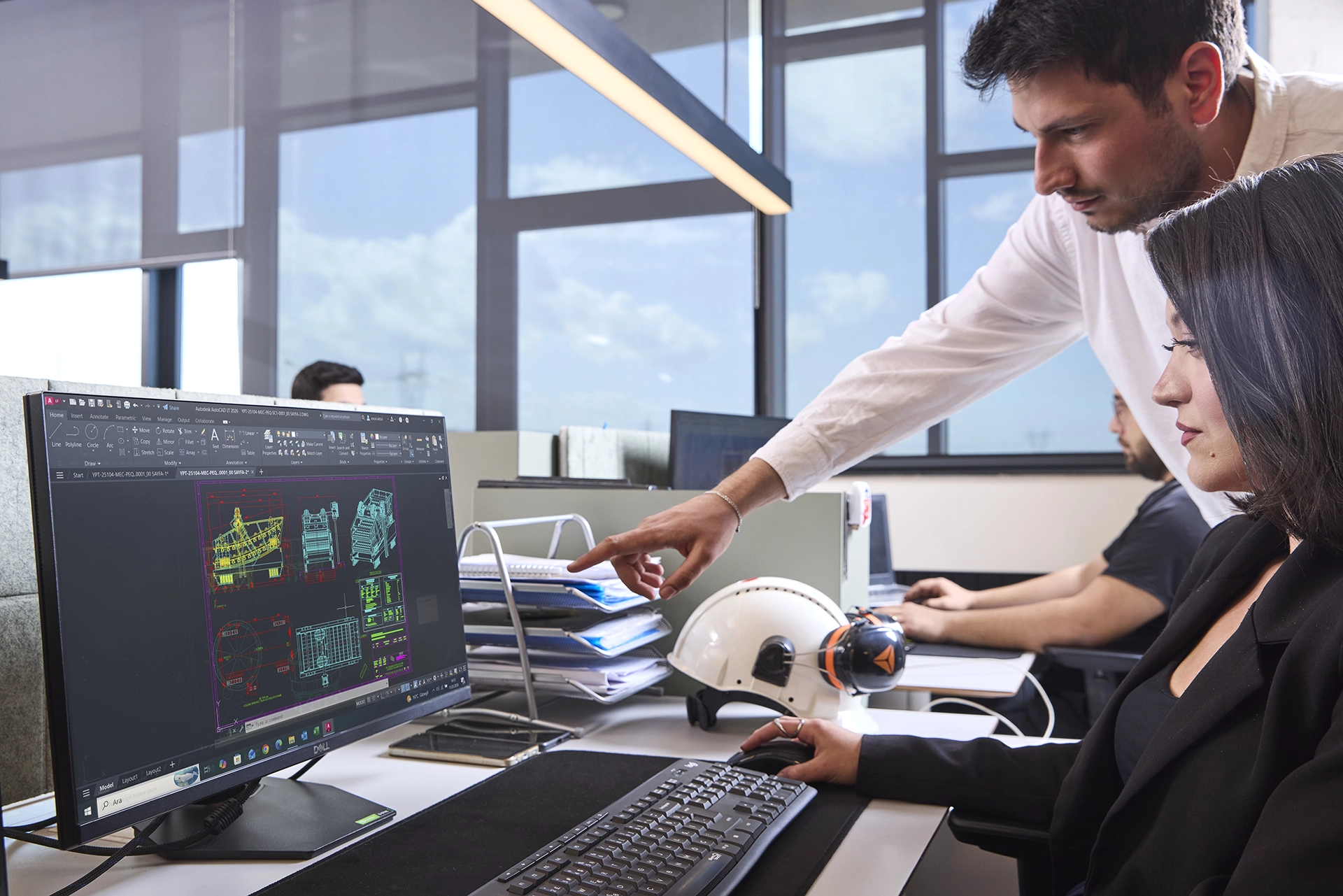 Corporate team members working in a modern office environment, collaborating on digital projects and business operations.